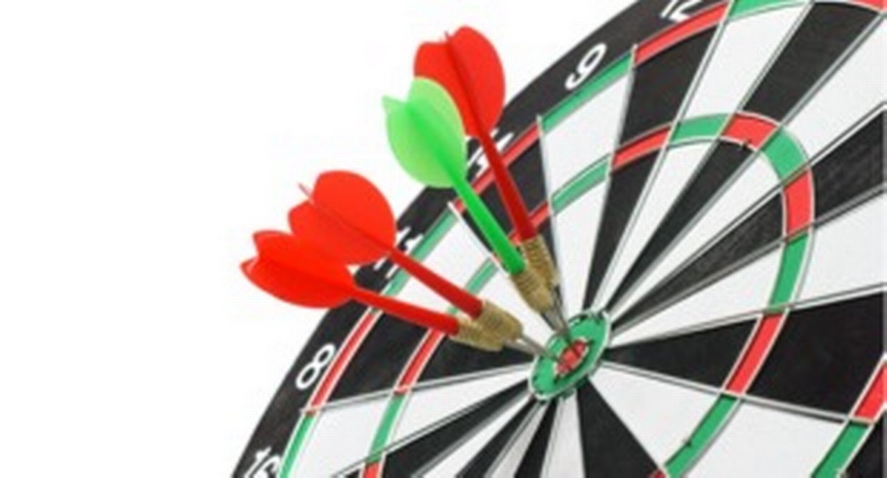 Close-up of four darts all bull's eye on dartboard