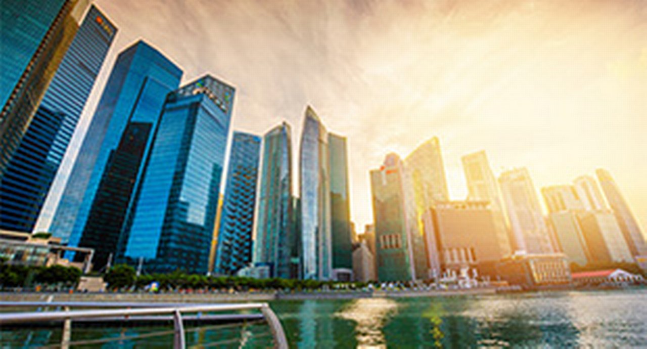 Tall office buildings with the sun hovering over them