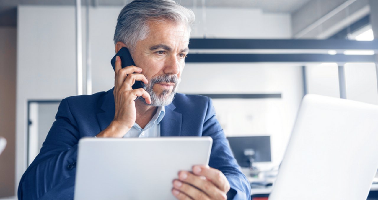 phoning man in front of screens