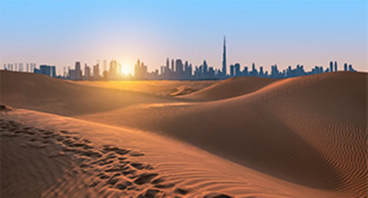 Desert dunes with the Dubai skyline in the background