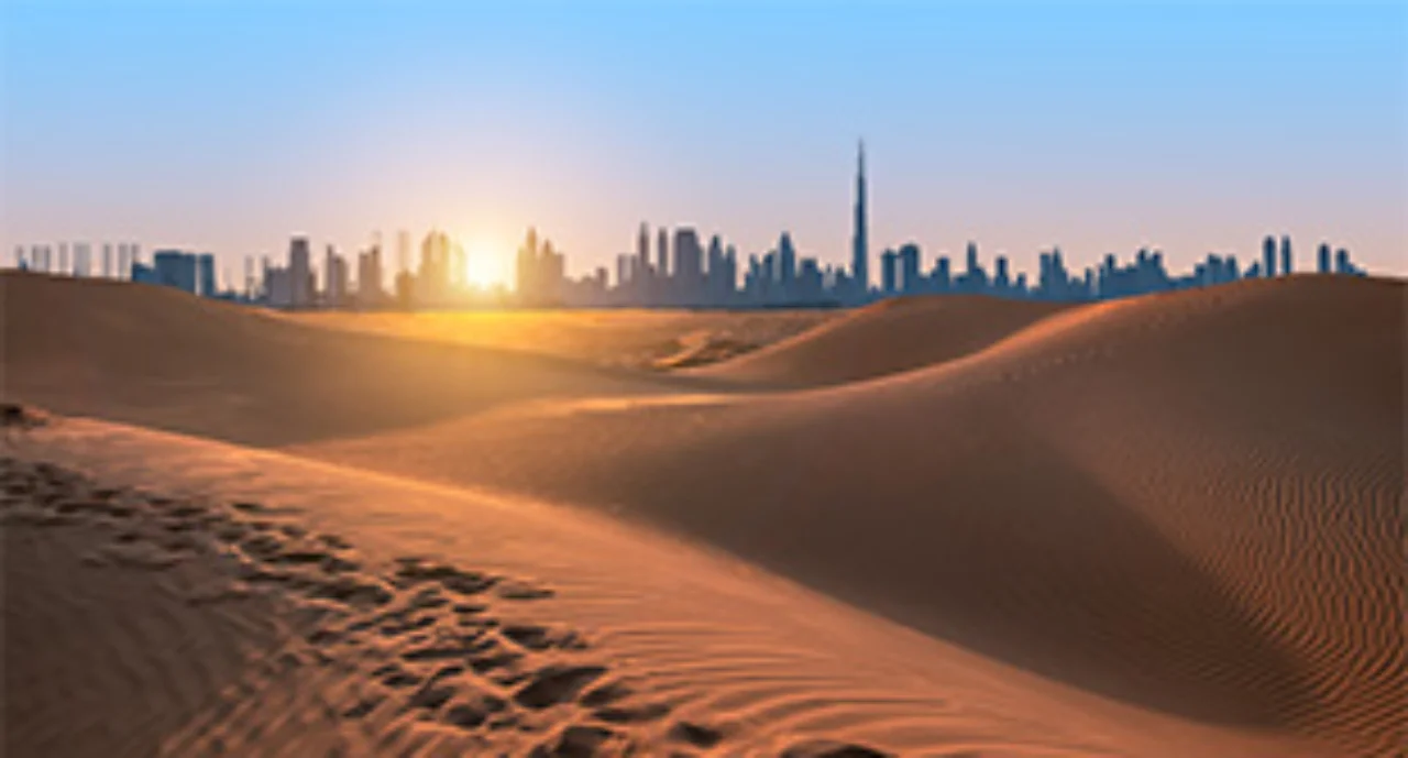 Desert dunes with the Dubai skyline in the background