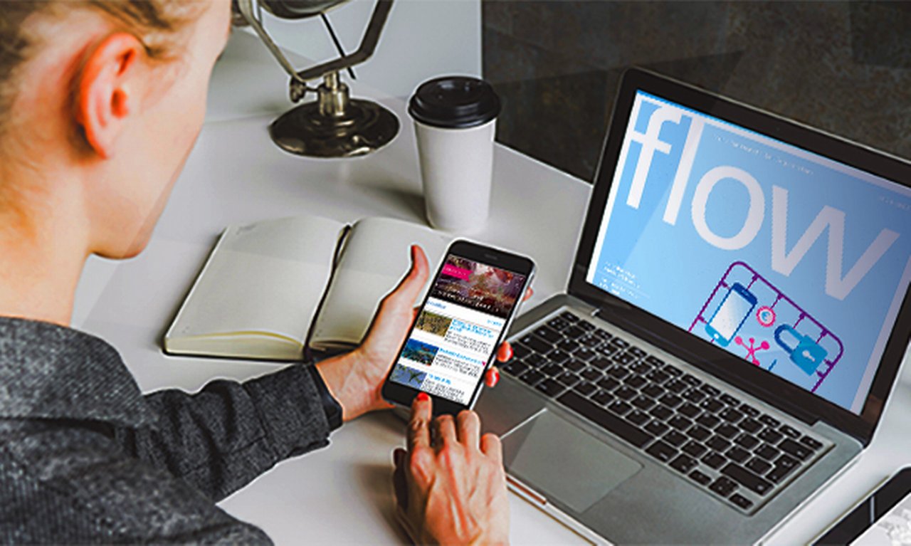 young professional reads flow magazine on her laptop