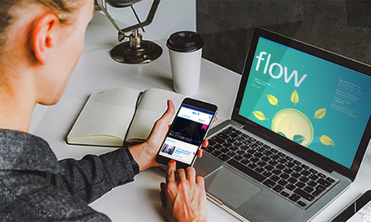 young professional reads flow magazine on her laptop