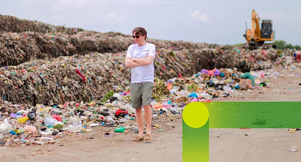 Man on the beach in front of a pile of garbage