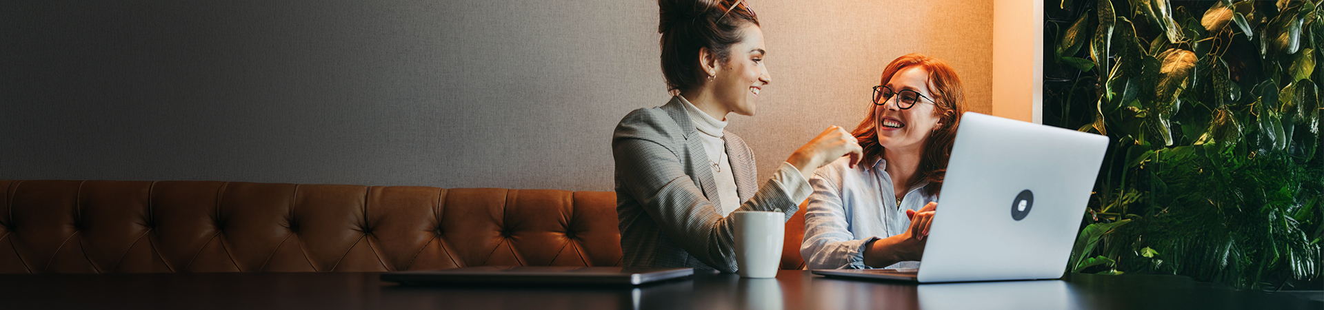 Two business women discussing in front of a laptop