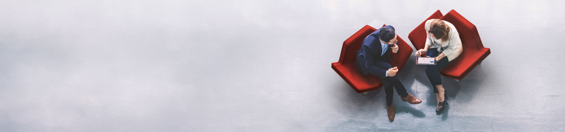 Two people sitting on red chairs