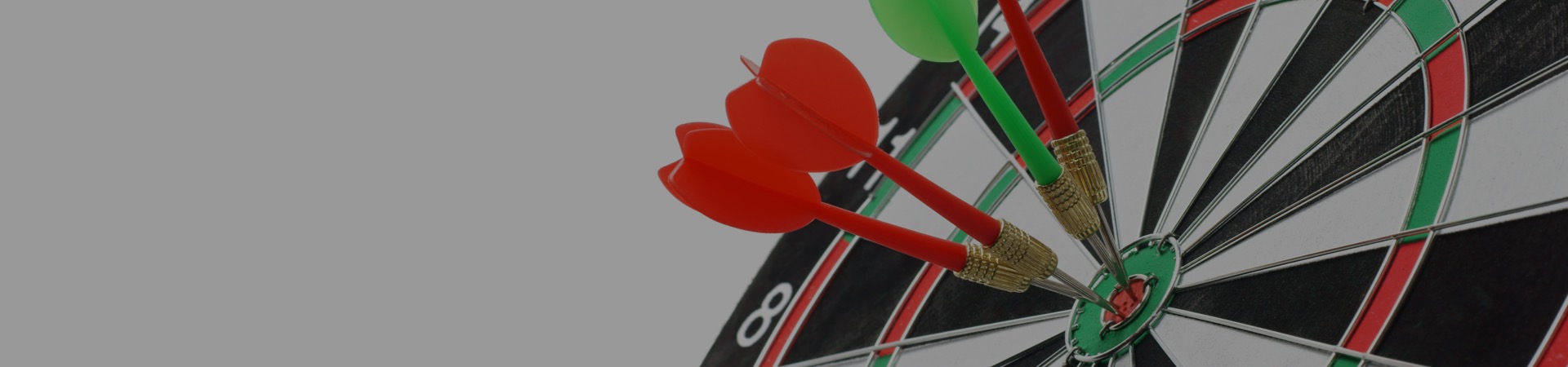 Close-up of four darts all bull's eye on dartboard
